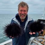 Dave Rudie, founder of Catalina Offshore Products Inc, holding a pair of sea urchins